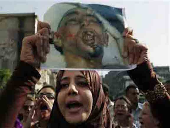 A woman carries an image of Khaled Said, tortured to death by police, at a 2010 Egyptian protest against his murder